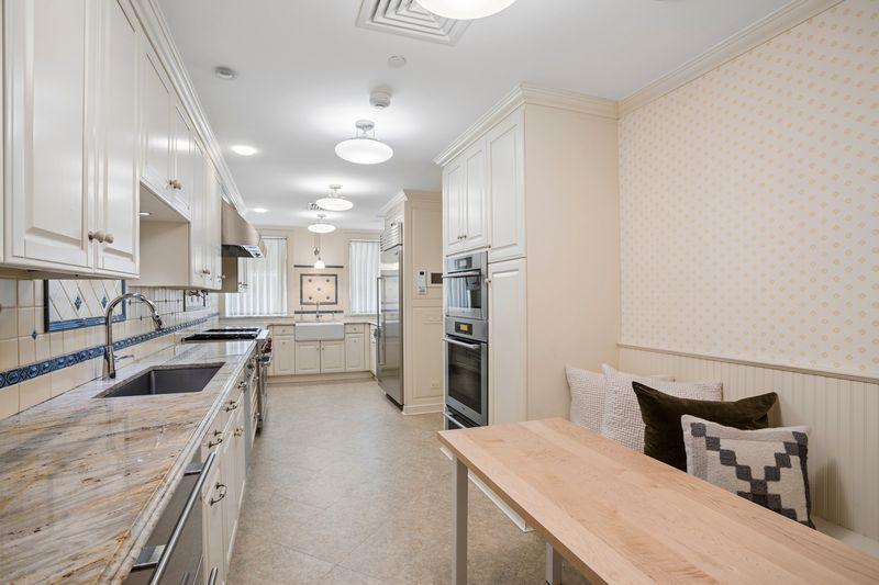 Eat-in kitchen with banquette and patterned wallpaper at 111 East 81st Street, Upper East Side