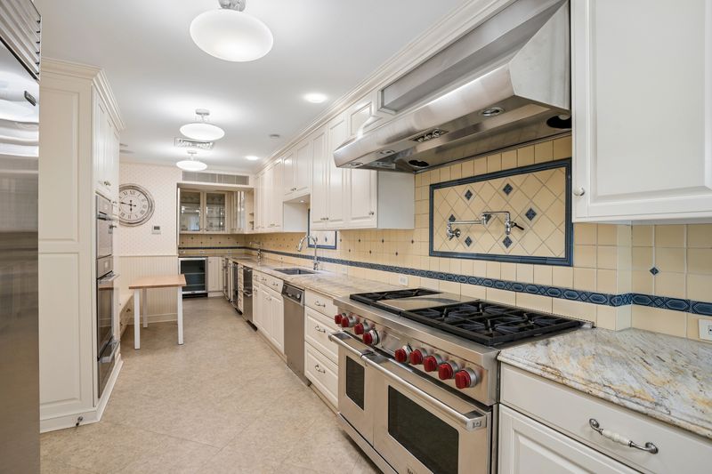 Galley kitchen with Wolf range and pot filler at 111 East 81st Street, Upper East Side — photo 2 of 8