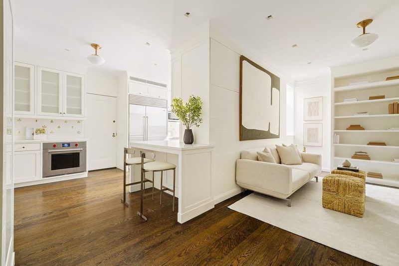 Kitchen and den with custom millwork bookcases at 1155 Park Avenue 10SW, Carnegie Hill — photo 5 of 12