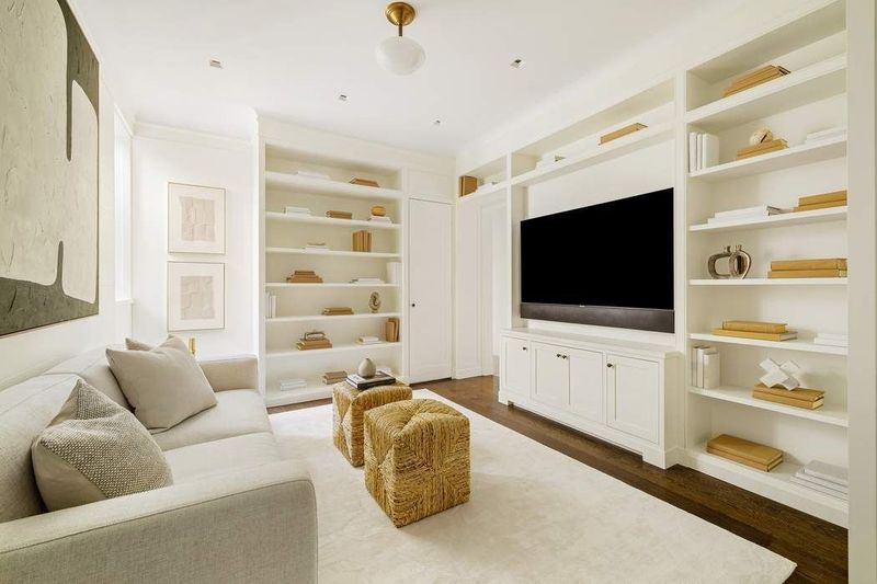 Den lined with custom bookcases and built-in cabinetry at 1155 Park Avenue 10SW, Carnegie Hill — photo 6 of 12