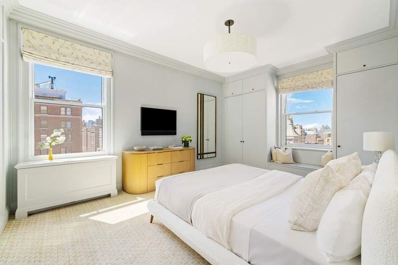Bedroom with two windows and built-in storage at 1155 Park Avenue 10SW, Carnegie Hill — photo 7 of 12