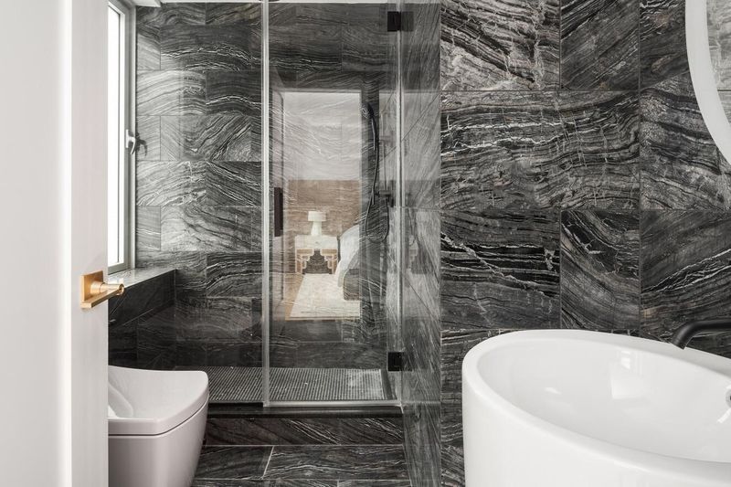 Primary bath with freestanding tub and glass shower in veined marble at 1200 Fifth Avenue 15A, Carnegie Hill — photo 6 of 13