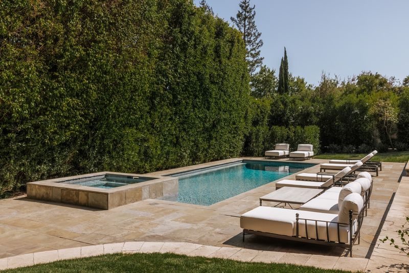 Pool and spa framed by towering hedges at 1228 Amalfi Drive, Pacific Palisades — photo 4 of 12