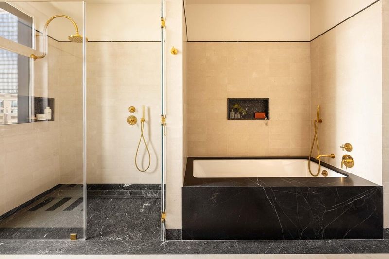 Primary bath with black-stone soaking tub at 127 Kent Avenue PH1A, Williamsburg — photo 6 of 8