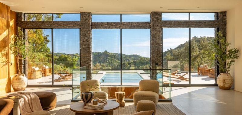 Great room with floor-to-ceiling glass and pool beyond at 12752 Mulholland Drive, Beverly Hills — photo 4 of 8