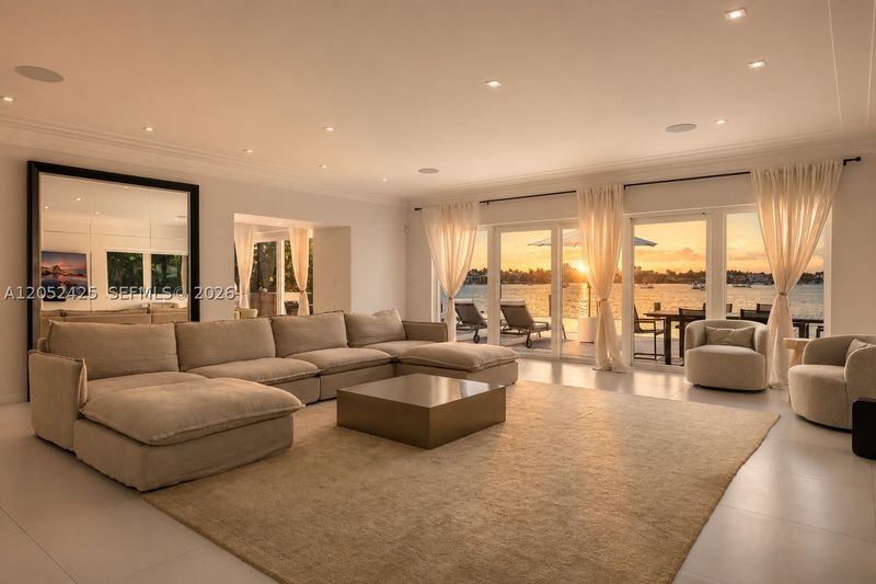 The living room, with walls of glass opening to the bay at 1300 South Venetian Way, San Marco Island — photo 4 of 10