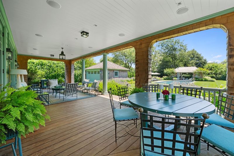 Covered outdoor dining porch overlooking the lawn at 134 Herrick Road, Southampton Village — photo 8 of 12