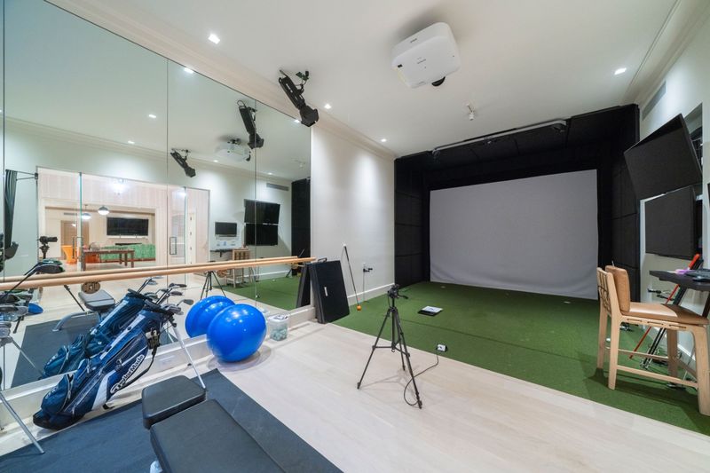 Golf simulator room beside the glass-enclosed gym at 134 Herrick Road, Southampton Village — photo 11 of 12