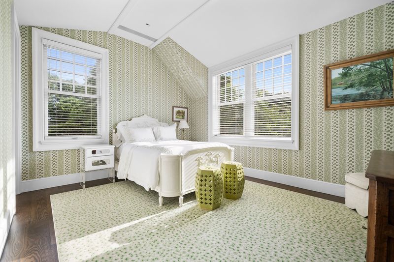 Bedroom with striped wallpaper and a garden-green rug at 134 Herrick Road, Southampton Village — photo 12 of 12