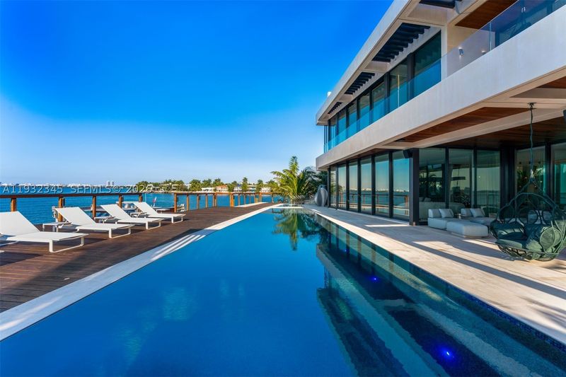 The 70-foot knife-edge pool along the bay at 1413 North Venetian Way, San Marco Island — photo 2 of 9