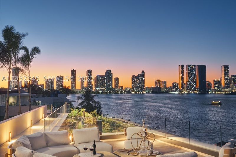 The terrace lounge at dusk, looking across the bay to the downtown skyline at 1413 North Venetian Way, San Marco Island — photo 3 of 9