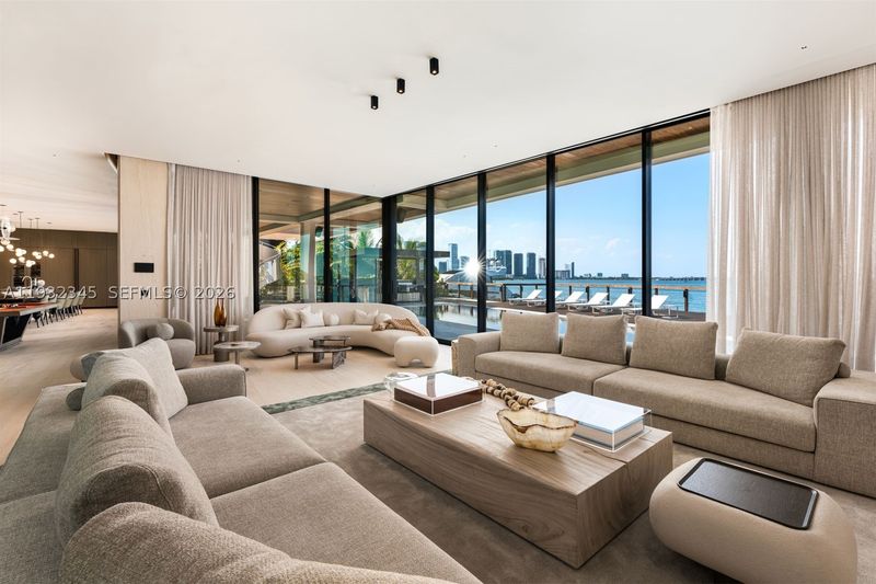 The great room, with 12-foot ceilings and floor-to-ceiling glass at 1413 North Venetian Way, San Marco Island — photo 5 of 9