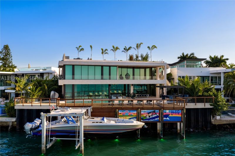 The home from the water, with the new dock and boat lift at 1413 North Venetian Way, San Marco Island — photo 8 of 9