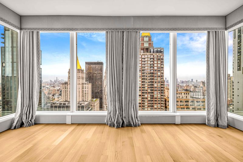 The corner living room with floor-to-ceiling windows and skyline views at 15 East 30th Street #33D, NoMad