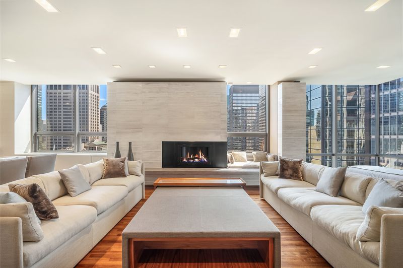 Living room with gas fireplace and corner floor-to-ceiling windows on Midtown at 15 West 53rd Street #29BC, Midtown Manhattan