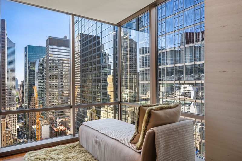 Corner window seating with Midtown tower views at 15 West 53rd Street #29BC, Midtown Manhattan — photo 4 of 12