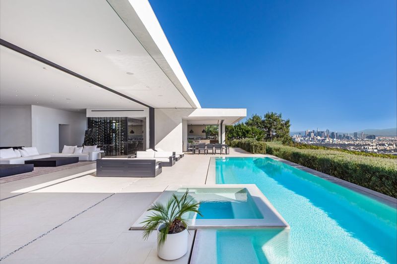 Pool and glass-walled living room opened to the terrace at 1535 Carla Ridge, Trousdale Estates — photo 2 of 10