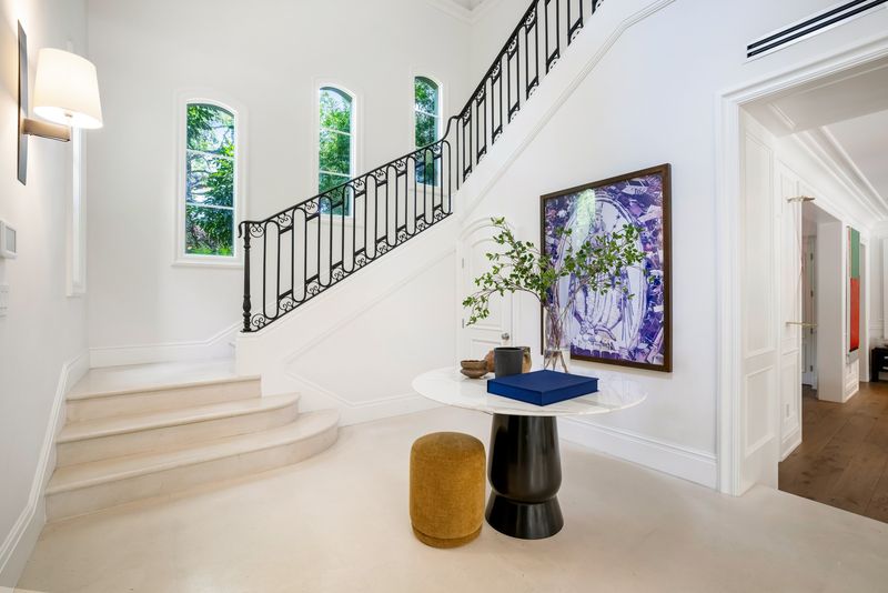Foyer stair with black-iron railings at 155 San Souci Drive, Coral Gables — photo 7 of 9