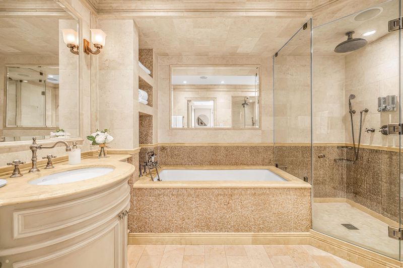 Primary bath with curved vanity, soaking tub and rain shower at 160 Central Park South 915, Central Park South — photo 3 of 6