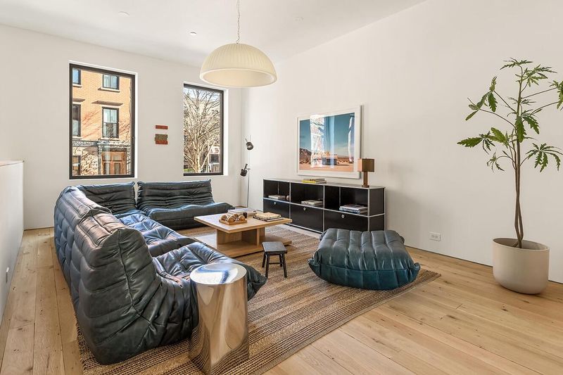 Living room with leather sofa and tall windows at 172 North 6th Street, Williamsburg — photo 3 of 8