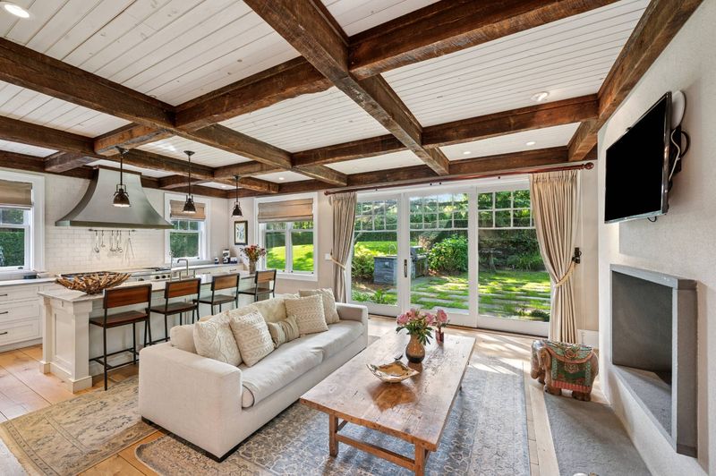 Family room with dark wood beams at 2 Borden Lane, East Hampton — photo 10 of 12