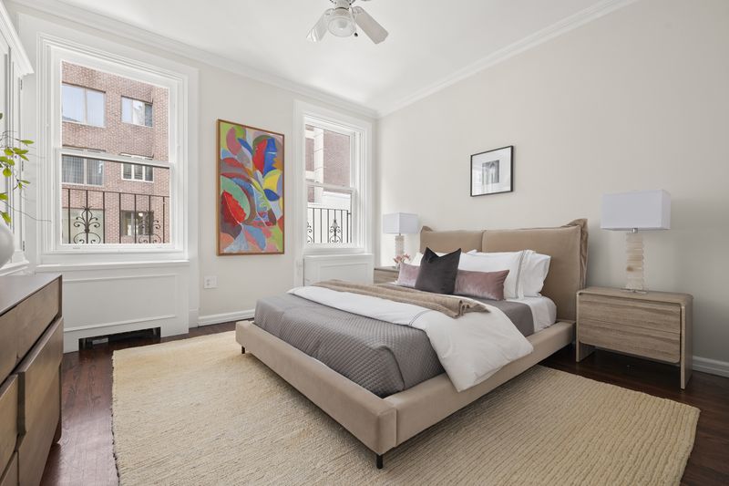 A bedroom with tall windows and a sitting chair at 2 East 80th Street #7, Upper East Side — photo 8 of 8