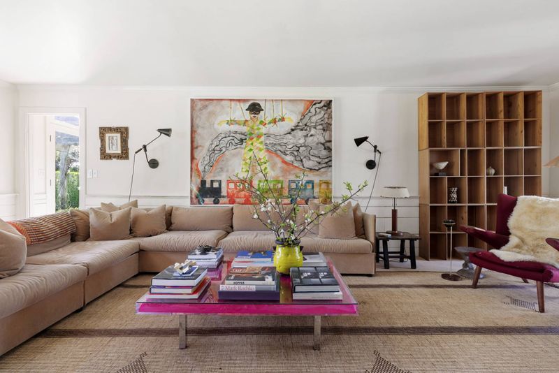 Sun-filled living room with sectional and built-in shelving at 216 Sagaponack Road, Bridgehampton — photo 4 of 12