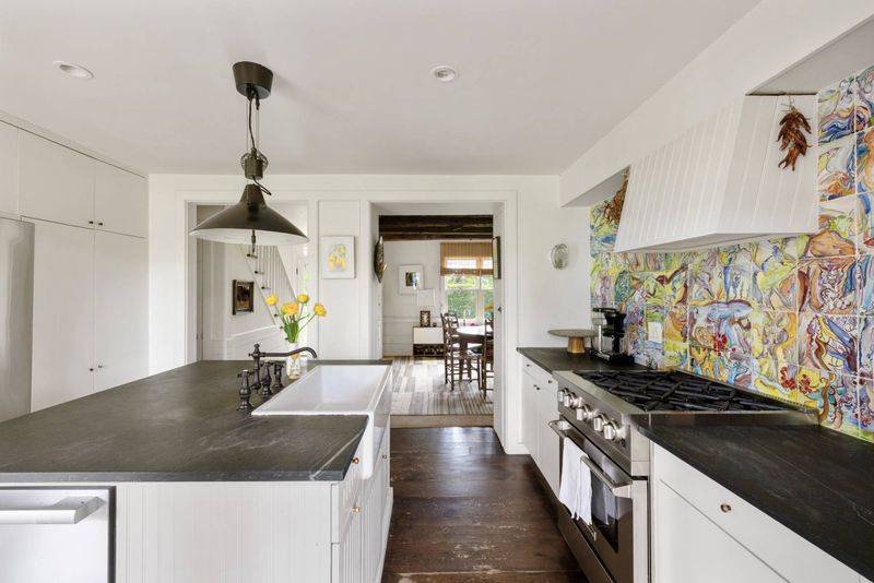 Kitchen with island, farmhouse sink and hand-painted tile at 216 Sagaponack Road, Bridgehampton — photo 5 of 12