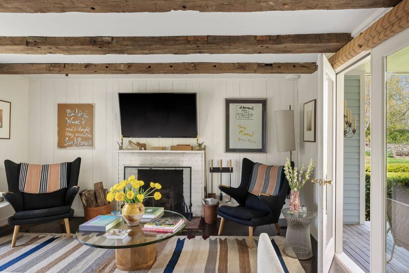 Den with fireplace and porch access at 216 Sagaponack Road, Bridgehampton — photo 10 of 12