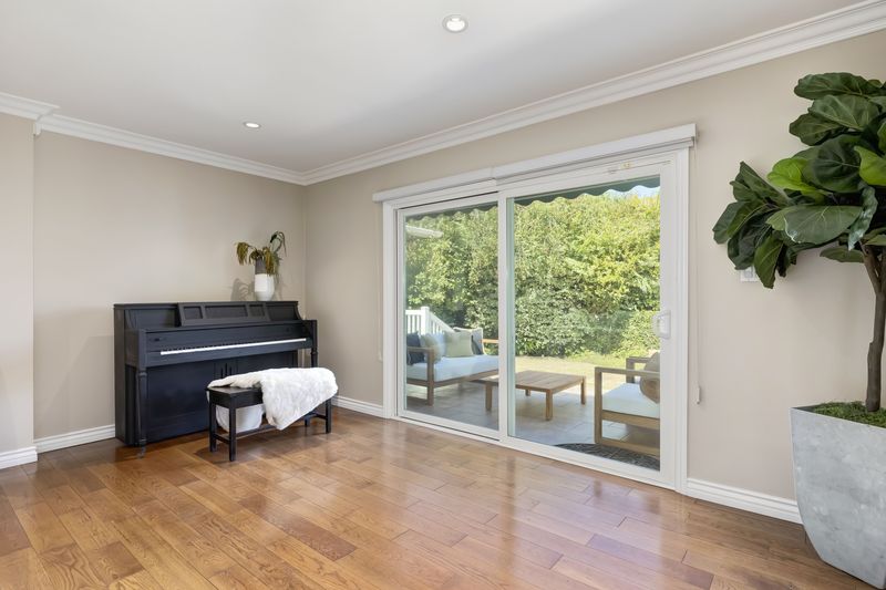 Living room toward sliding doors, piano, and patio at 2302 Duxbury Circle, Beverlywood — photo 4 of 8