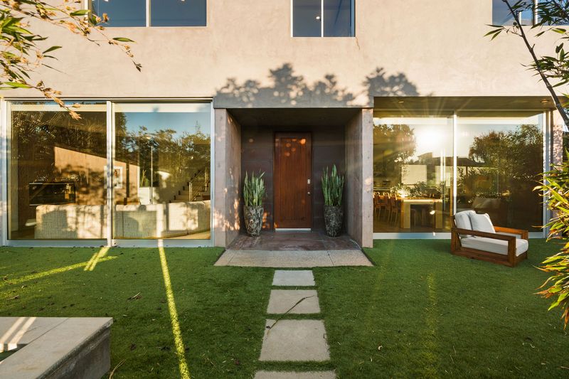 A stepping-stone path across the lawn to the glass-walled entry at 2324 Boone Avenue, Venice