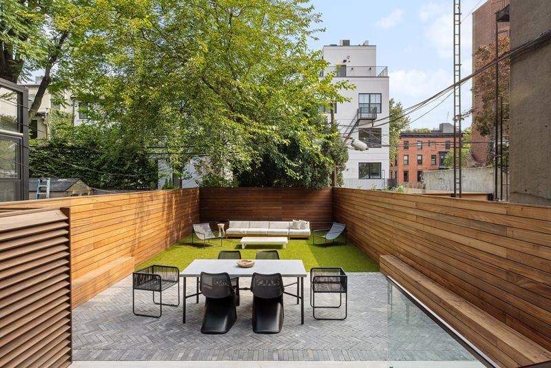 Private backyard with dining terrace and lawn at 235 Sackett Street #1, Carroll Gardens — photo 4 of 12
