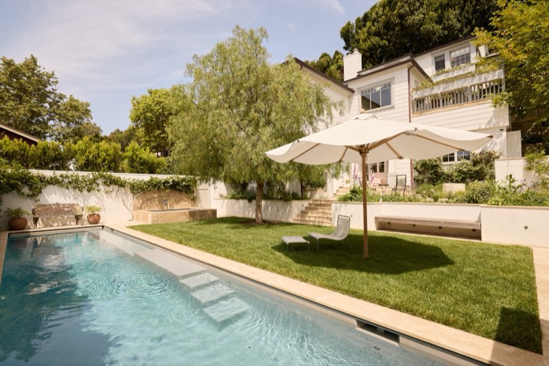 virtually staged rear pool, lawn, and house