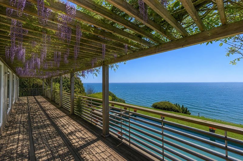 Wisteria-covered pergola and deck along the bay side of the house at 24 Aqua Drive, Southampton — photo 4 of 11