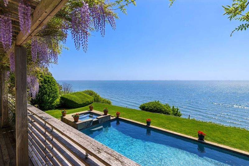 View from the deck over the pool, lawn and Shinnecock Bay at 24 Aqua Drive, Southampton — photo 10 of 11