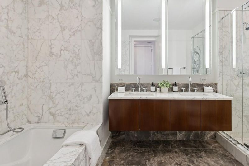 Primary bath with double vanity, soaking tub and glass shower at 25 Columbus Circle 57B, Columbus Circle — photo 6 of 8