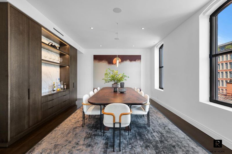 Dining area with custom walnut built-in bar wall at 250 West Street 9JK, Tribeca — photo 5 of 12