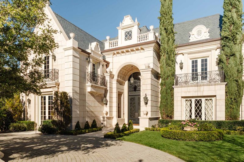 Arched entry with wrought-iron balcony at 25242 Prado Del Misterio, Calabasas — photo 2 of 8
