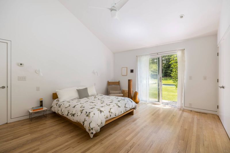 Primary bedroom with garden doors at 3 Whale Rock Lane, East Hampton — photo 8 of 8