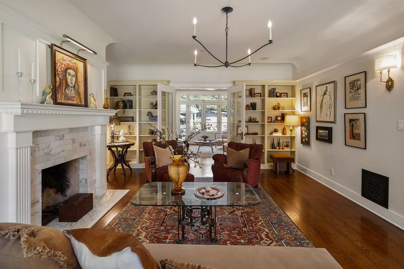 The living room, anchored by a wood-burning fireplace and flanked by built-in bookcases at 303 Markham Place, Pasadena — photo 2 of 12