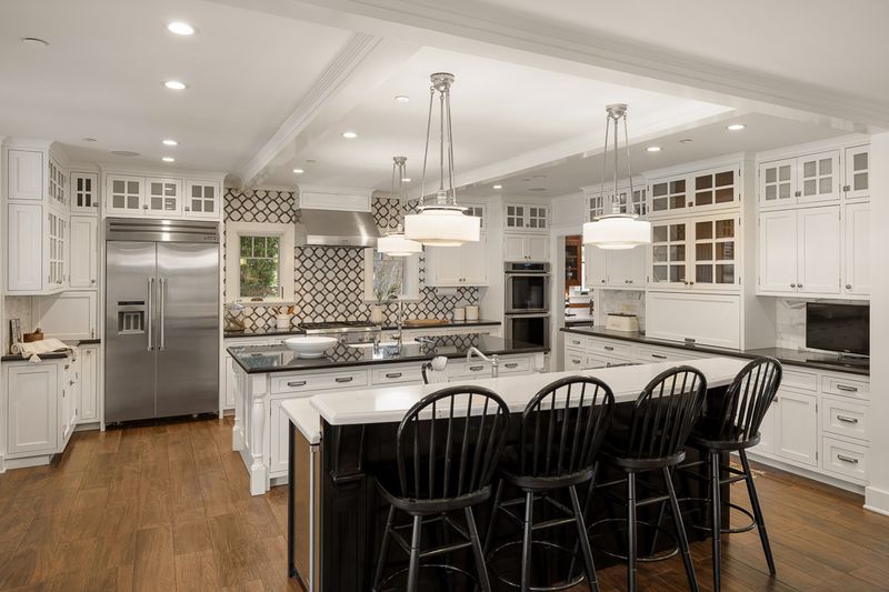 The chef's kitchen, with two islands, a breakfast bar and white custom cabinetry at 303 Markham Place, Pasadena — photo 3 of 12
