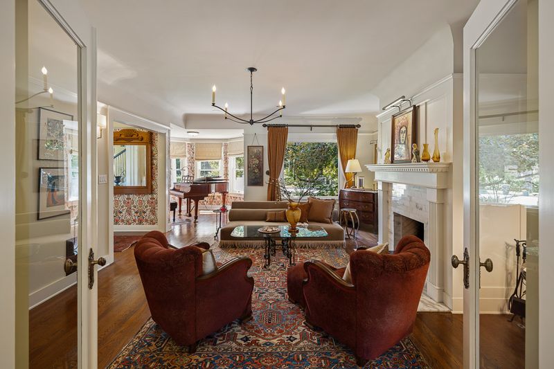 Another view of the living room, with leather club chairs and the fireplace at 303 Markham Place, Pasadena — photo 10 of 12