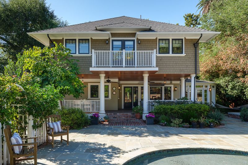 The back of the house, with its upper balcony, seen across the pool terrace at 303 Markham Place, Pasadena — photo 11 of 12