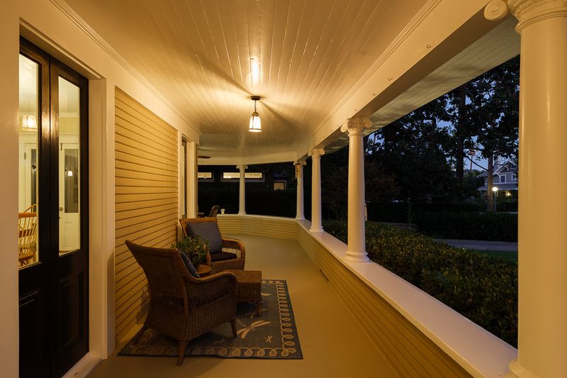 The wraparound porch at dusk, with its classical columns and lantern light at 303 Markham Place, Pasadena — photo 12 of 12