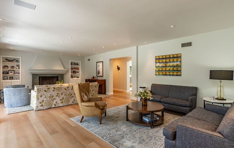 The living room, with a fireplace, built-in shelving and wide-plank oak floors at 3101 Fryman Road, Studio City — photo 4 of 12