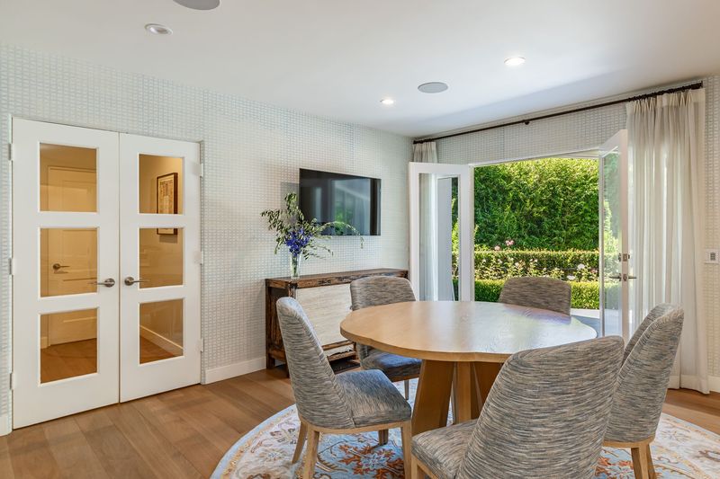 A breakfast area with a round table and French doors open to the garden at 3101 Fryman Road, Studio City — photo 10 of 12