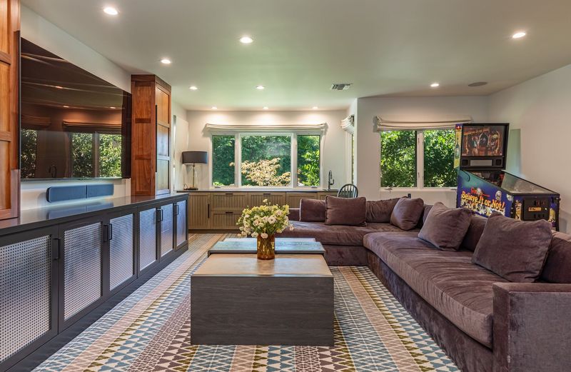 The family and media room, with a large sectional and a vintage pinball machine at 3101 Fryman Road, Studio City — photo 11 of 12