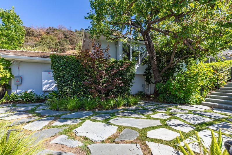 A flagstone garden path and stone steps lead up to the house through mature trees at 3101 Fryman Road, Studio City — photo 12 of 12