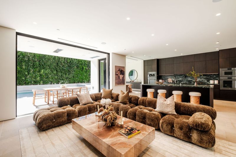 Living room opening through pocket doors to the garden at 317 South Wetherly Drive, Beverly Hills — photo 2 of 9