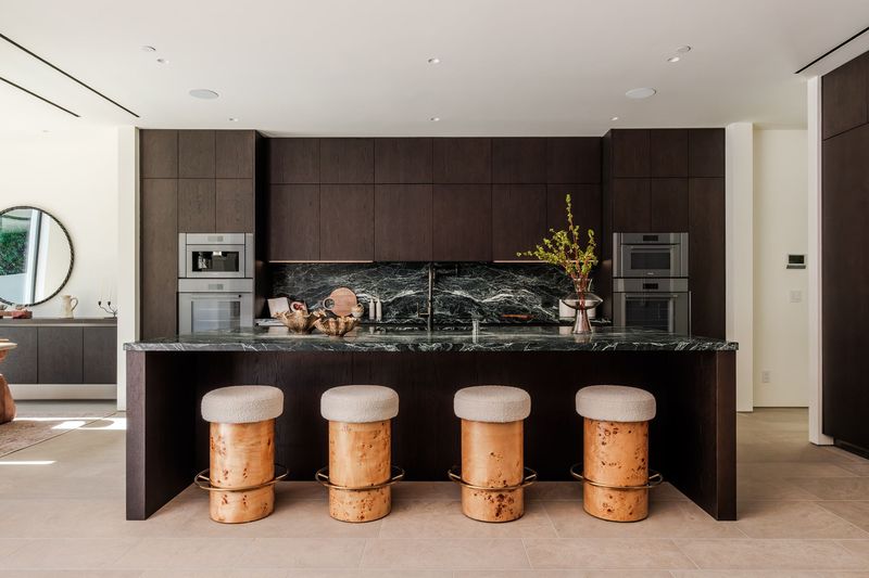 Chef's kitchen with dark wood cabinetry and an Alpi Verde marble island at 317 South Wetherly Drive, Beverly Hills — photo 3 of 9